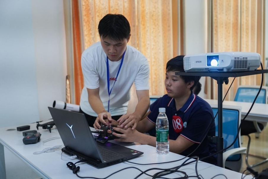 beat365中文官方网站信息工程学院学生正在指导研学团成员操控无人机。